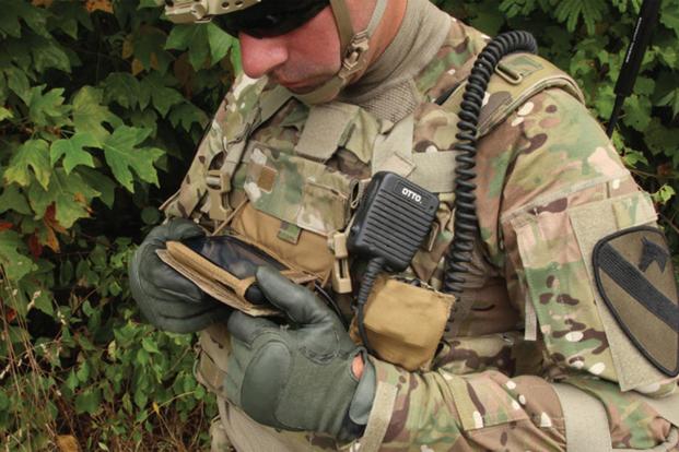 Солдат в форме США смотрит в экран смартфона