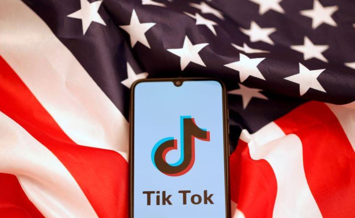Смартфон с логотипом ТикТок лежит на флаге США