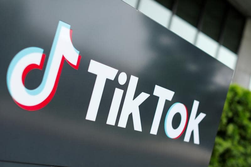 Надпись и логотип ТикТок на чёрном фоне