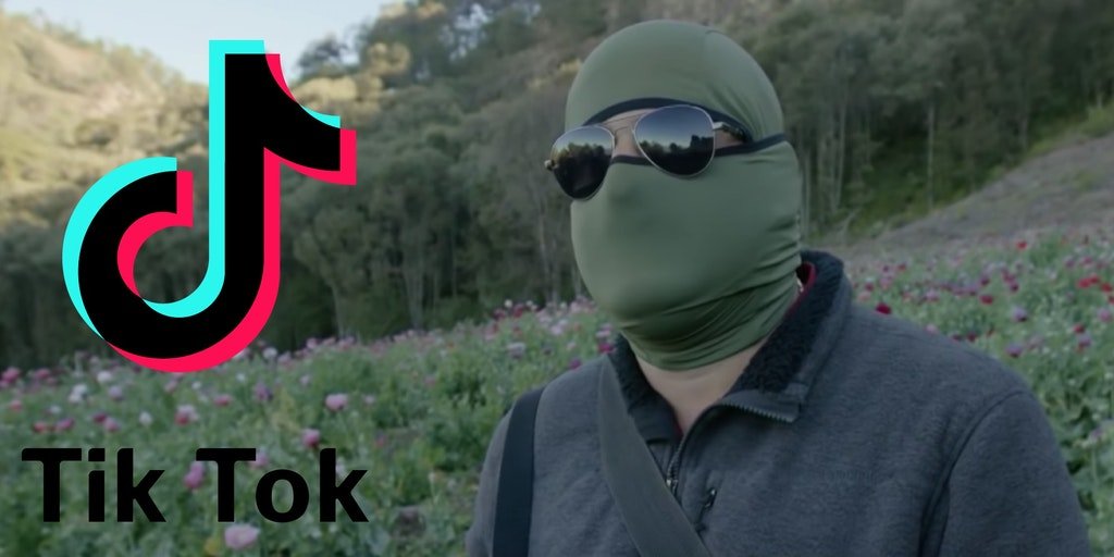 Человек в маске и солнцезащитных очках, скрывающих глаза, стоит рядом с логотипом ТикТок