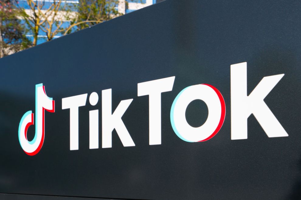 Логотип ТикТок на чёрной стене