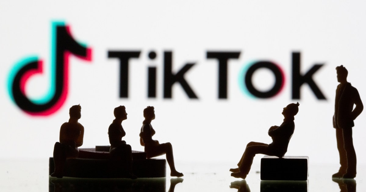 Силуэты людей на фоне логотипа ТикТок