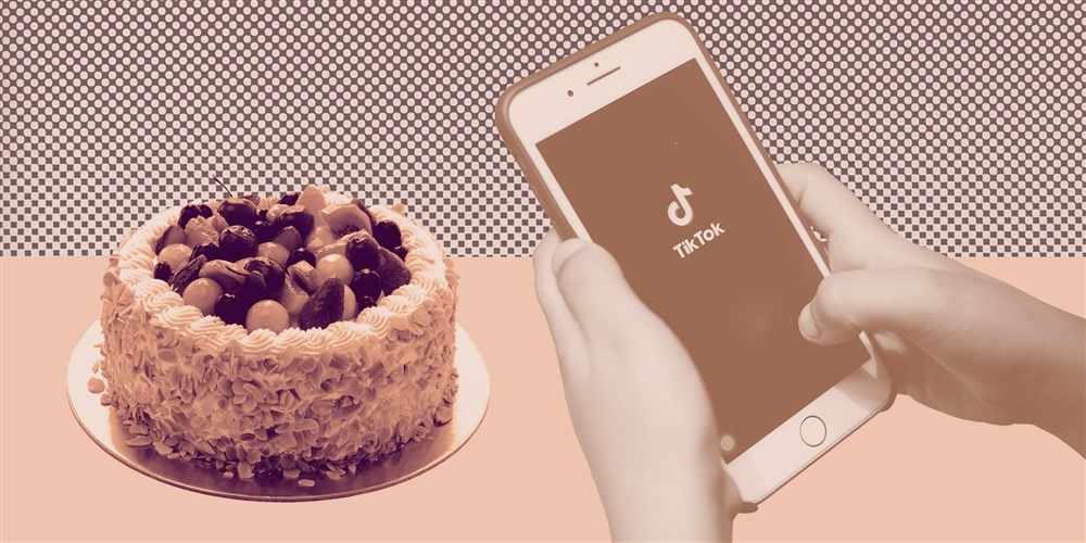 Смартфон с логотипом ТикТок на экране и торт